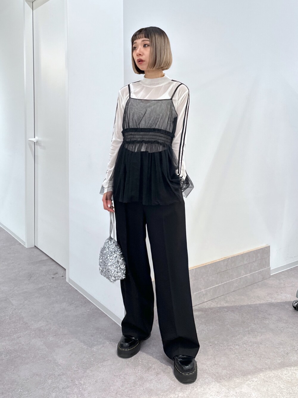 ホワイト系のブルゾン、ブラック系のシャツ/ブラウス、ホワイト系のTシャツ/カットソーを着用したレディースの冬コーディネートの3枚目の写真