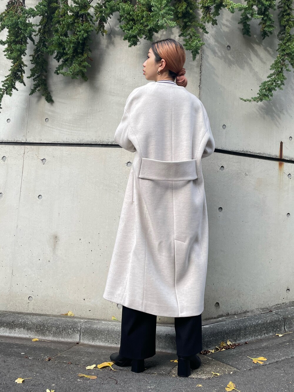 ブラック系のその他パンツ、ブラック系のブーツ、ベージュ系のノーカラーコートを着用したレディースの秋コーディネートの4枚目の写真