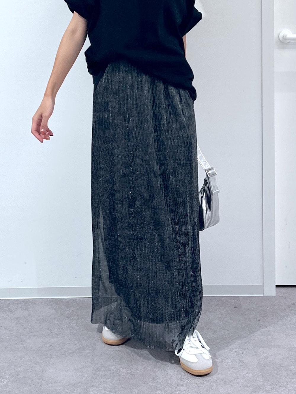 ブラック系のTシャツ/カットソー、ブラック系のスカート、シルバー系のショルダーバッグを着用したレディースの春コーディネートの6枚目の写真