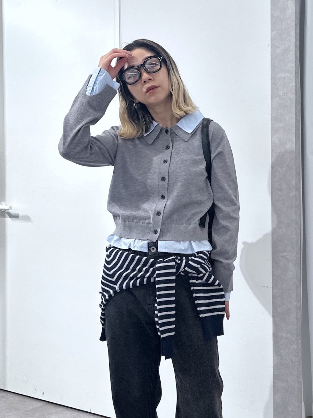 グレー系のニット/セーター、ブルー系のニット/セーター、ブラック系のデニムパンツを着用したレディースの春コーディネートの4枚目の写真