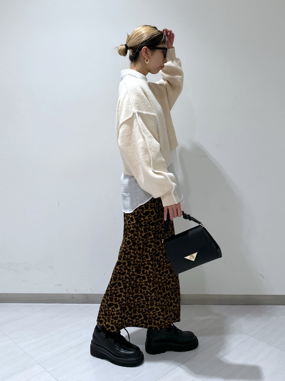 ホワイト系のニット/セーター、ホワイト系のシャツ/ブラウス、ブラウン系のスカートを着用したレディースの冬コーディネートの2枚目の写真