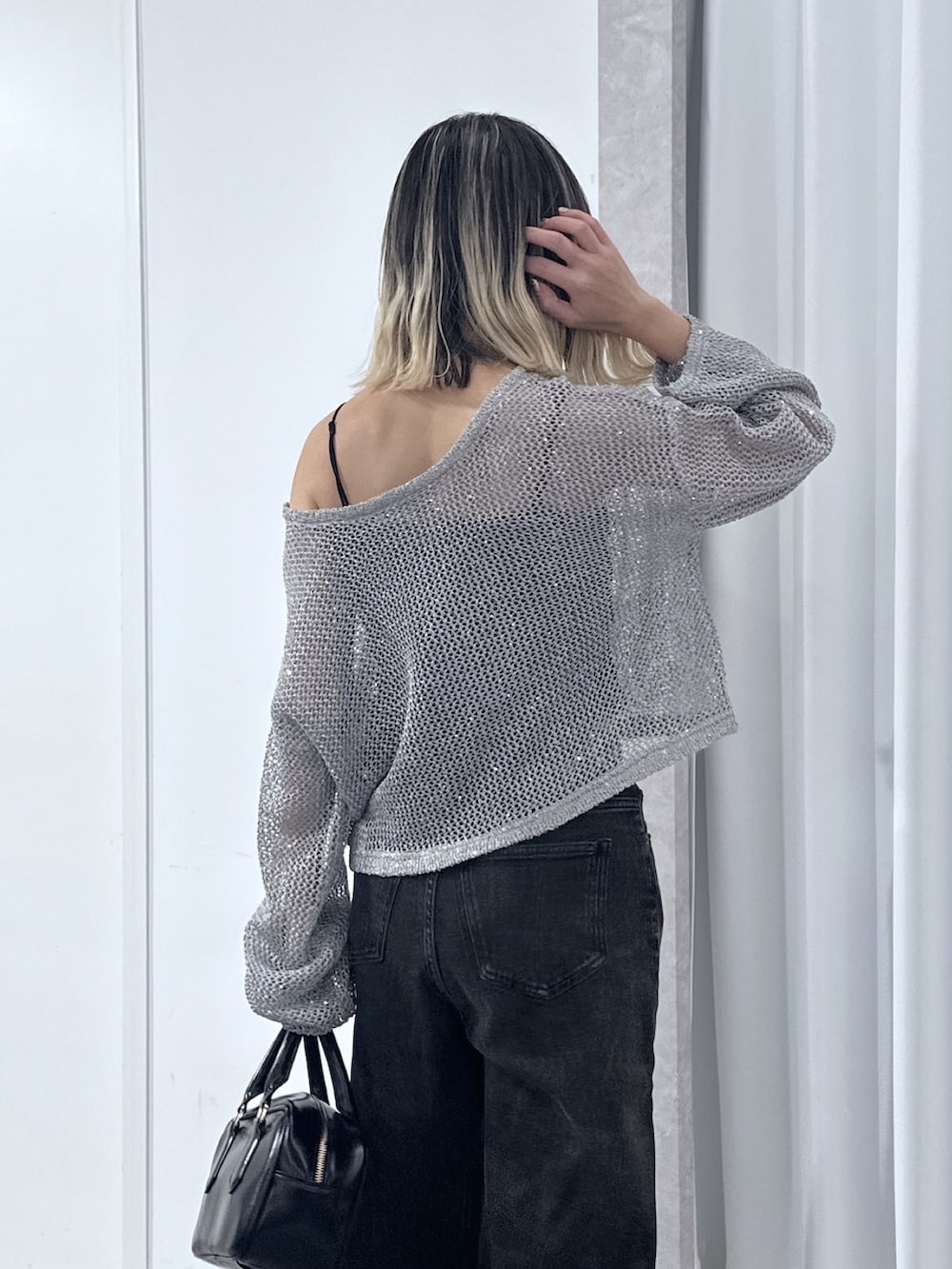 ブラック系のデニムパンツ、グレー系のニット/セーター、ブラック系のキャミソールを着用したレディースの春コーディネートの6枚目の写真