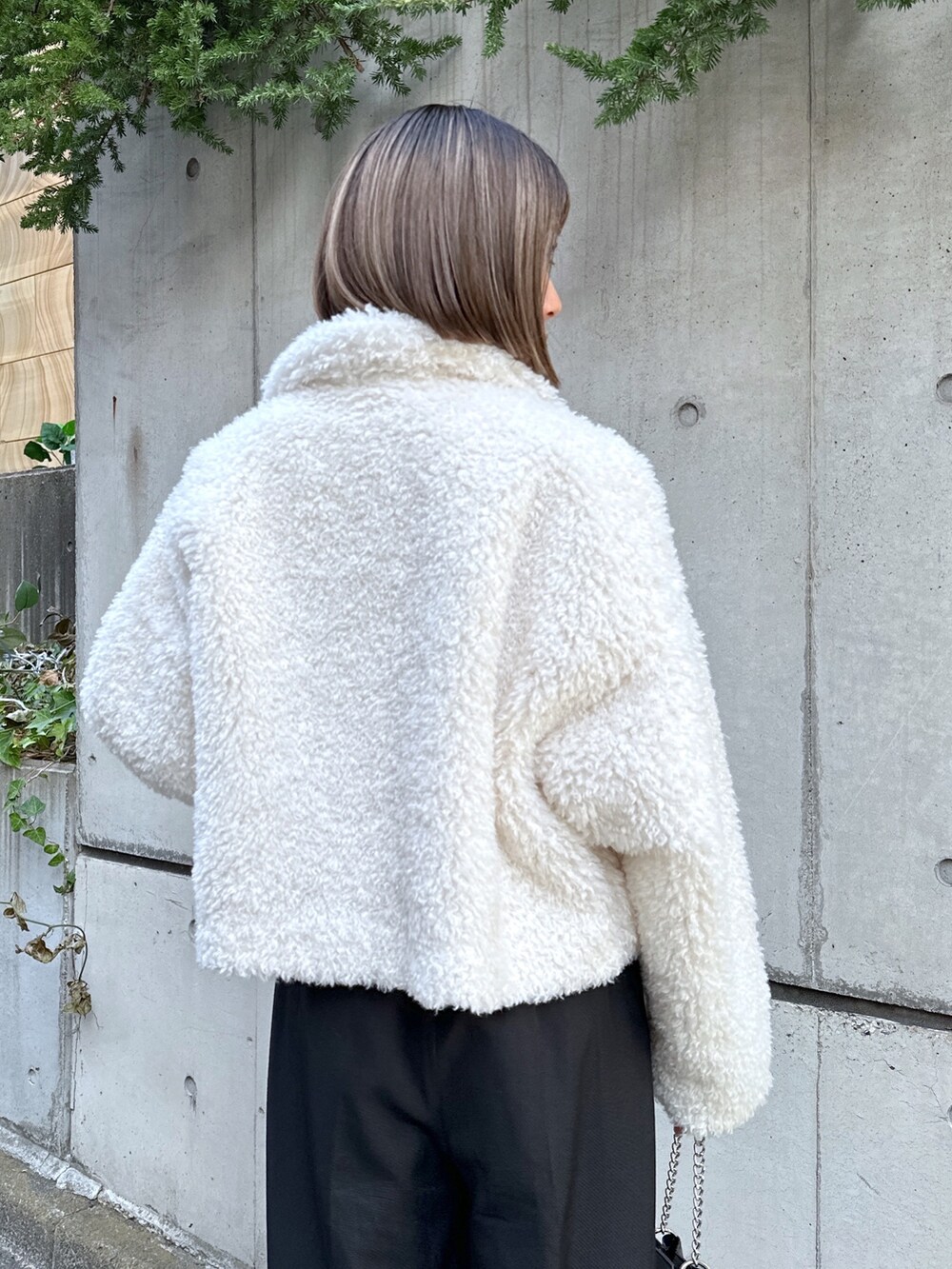 ホワイト系のブルゾン、ホワイト系のニット/セーター、ブラック系のその他パンツを着用したレディースの秋コーディネートの3枚目の写真