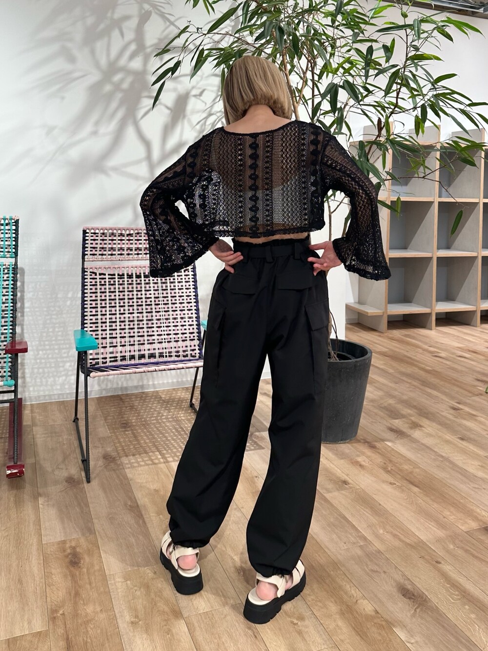 ブラック系のカーディガン/ボレロ、ブラック系のカーゴパンツ、ホワイト系のサンダルを着用したレディースの夏コーディネートの2枚目の写真