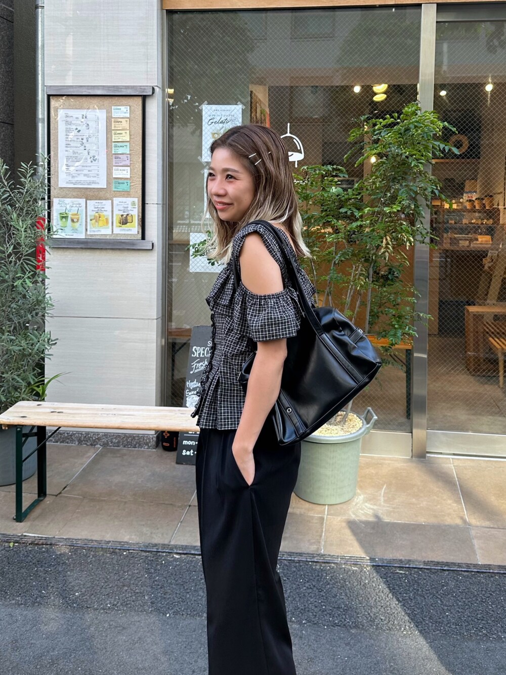 ブラック系のシャツ/ブラウス、ブラック系のスラックス、ブラック系のショルダーバッグを着用したレディースの夏コーディネートの6枚目の写真