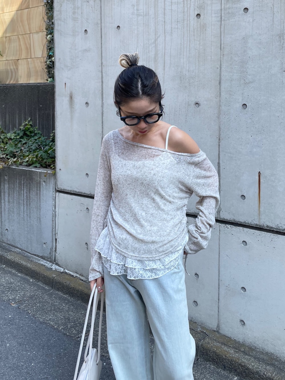 ホワイト系のTシャツ/カットソー、ブルー系のデニムパンツ、ホワイト系のショルダーバッグを着用したレディースの冬コーディネートの3枚目の写真