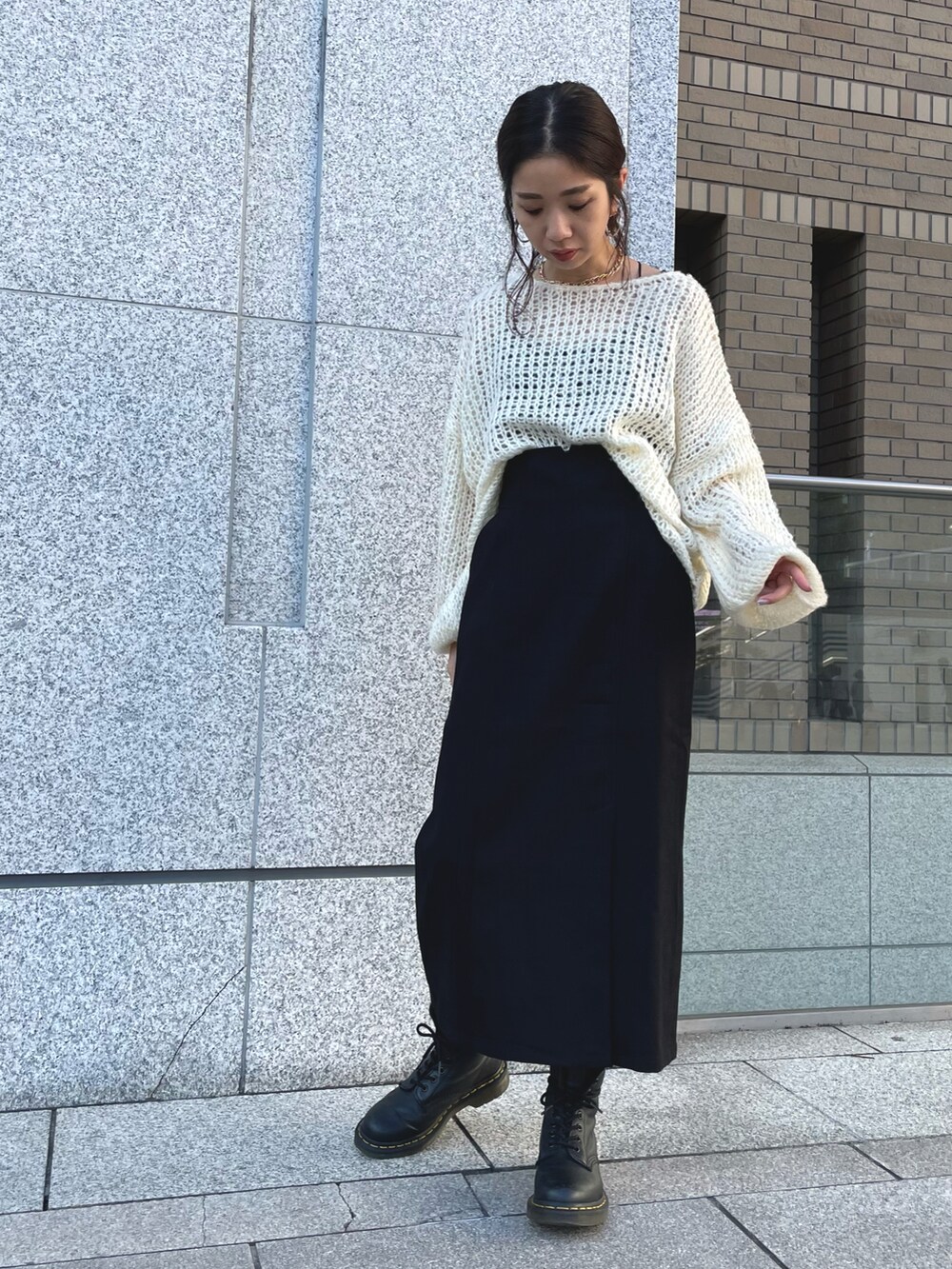 ブラック系のスカート、ホワイト系のニット/セーターを着用したレディースの秋コーディネートの2枚目の写真