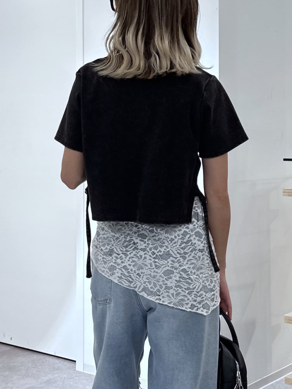 ブラック系のTシャツ/カットソー、ブルー系のデニムパンツ、ブラック系のハンドバッグを着用したレディースの夏コーディネートの5枚目の写真
