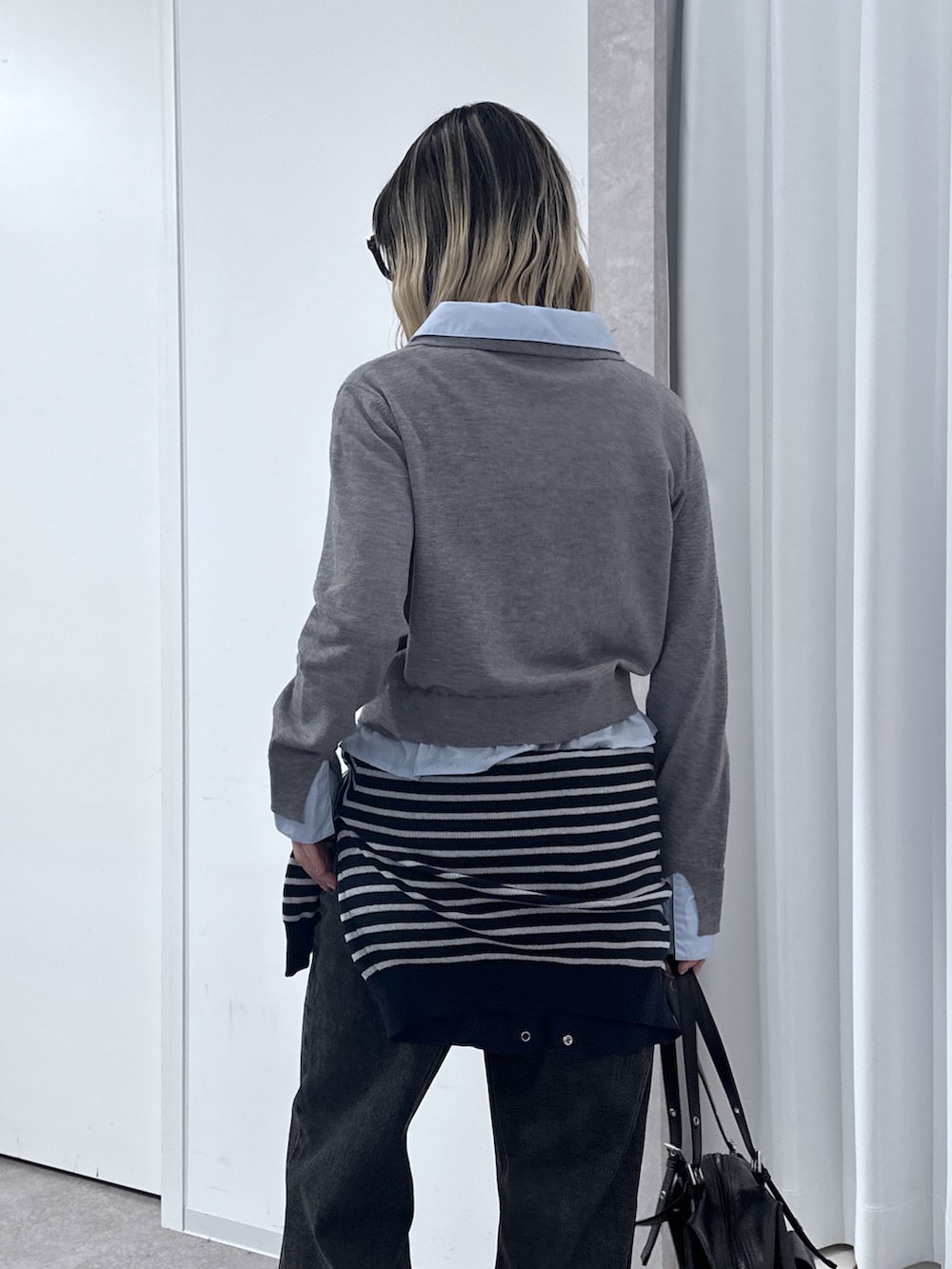 グレー系のニット/セーター、ブルー系のニット/セーター、ブラック系のデニムパンツを着用したレディースの春コーディネートの5枚目の写真