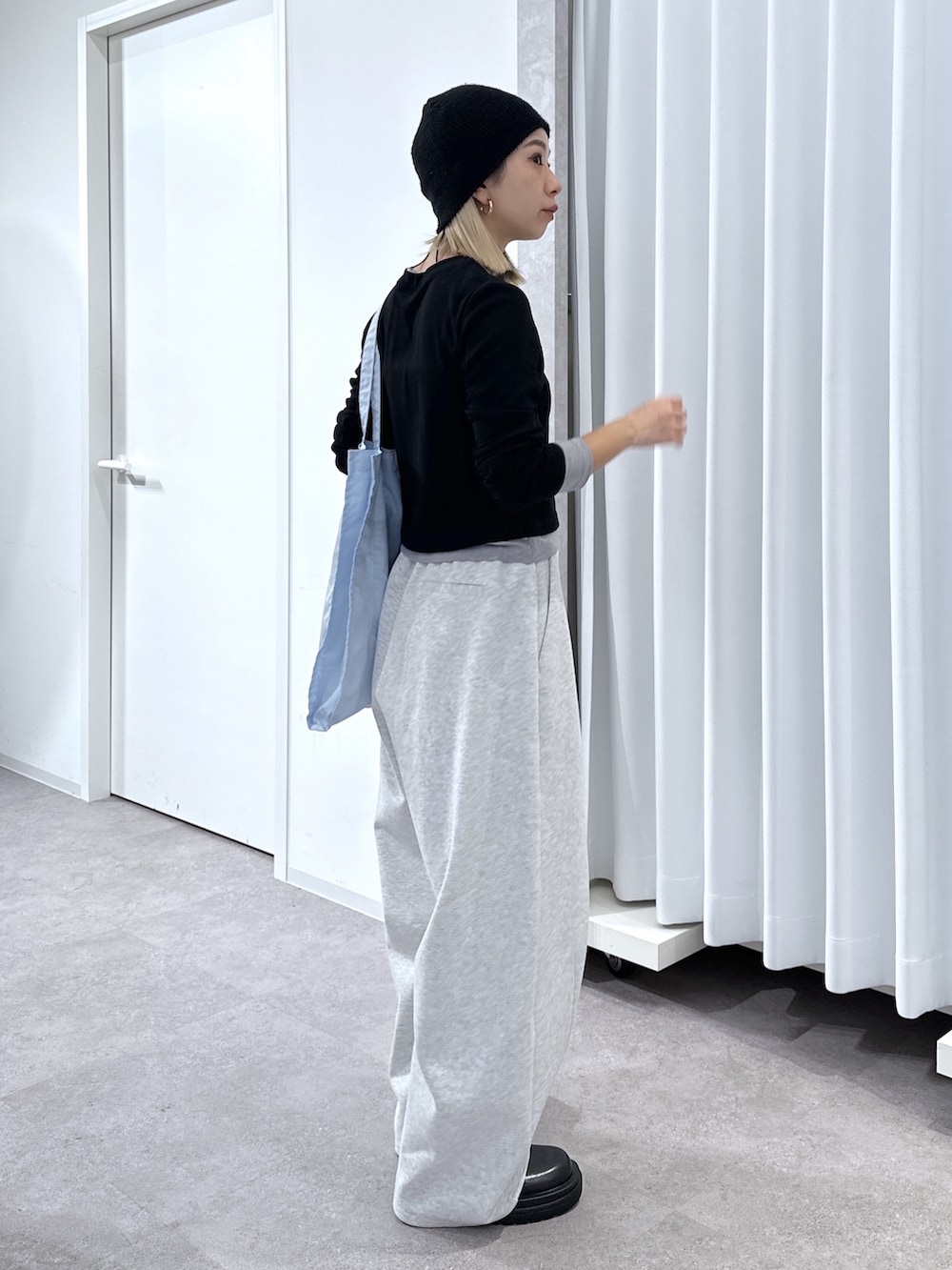 ブラック系のTシャツ/カットソー、ホワイト系のその他パンツ、ブルー系のトートバッグを着用したレディースの春コーディネートの2枚目の写真