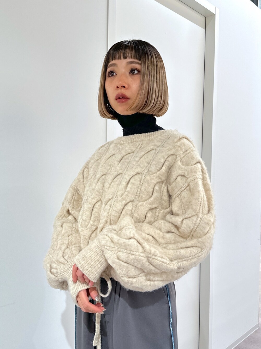 ホワイト系のニット/セーター、グレー系のその他パンツ、ブラック系のショルダーバッグを着用したレディースの冬コーディネートの4枚目の写真