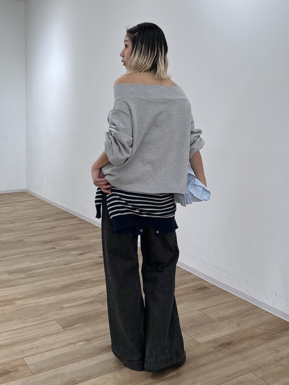 グレー系のTシャツ/カットソー、ブラック系のデニムパンツ、ブルー系のニット/セーターを着用したレディースの冬コーディネートの4枚目の写真