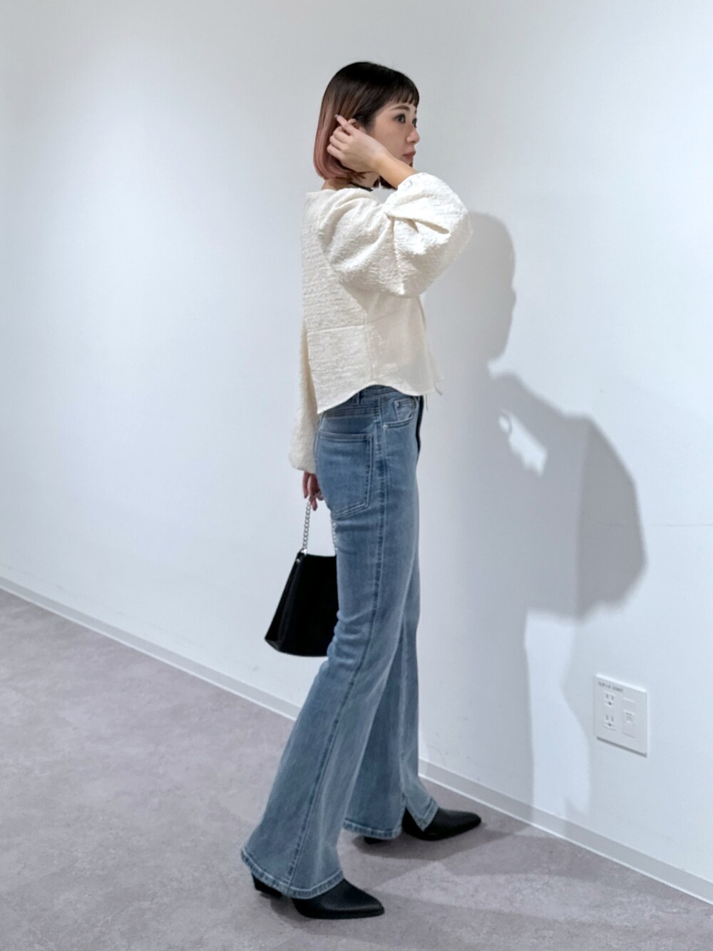 ホワイト系のシャツ/ブラウス、ブルー系のデニムパンツ、ブラック系のショルダーバッグを着用したレディースの冬コーディネートの3枚目の写真