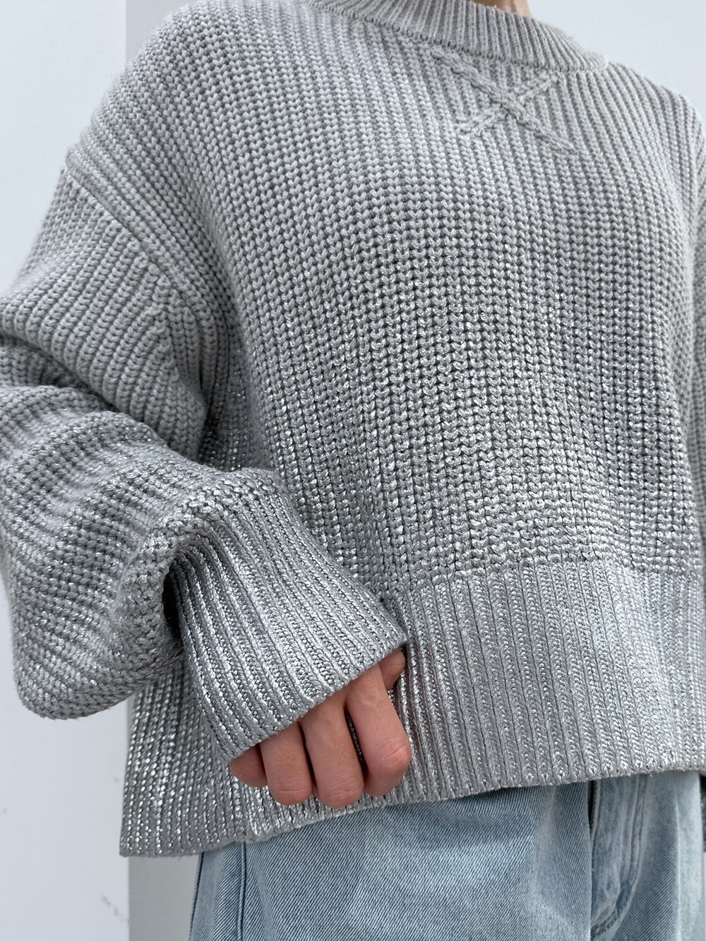 グレー系のニット/セーター、ブルー系のデニムパンツ、ブラック系のショルダーバッグを着用したレディースの冬コーディネートの6枚目の写真