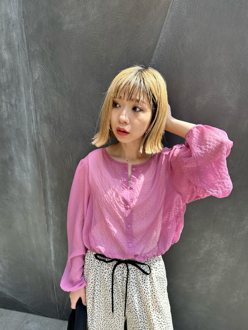 ピンク系のシャツ/ブラウス、ホワイト系のその他パンツ、ブラック系のトートバッグを着用したレディースの春コーディネートの3枚目の写真