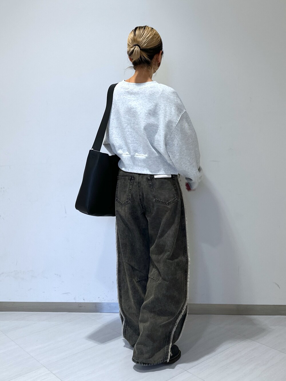 ホワイト系のスウェット、ブラック系のデニムパンツ、グレー系のブルゾンを着用したレディースの冬コーディネートの3枚目の写真