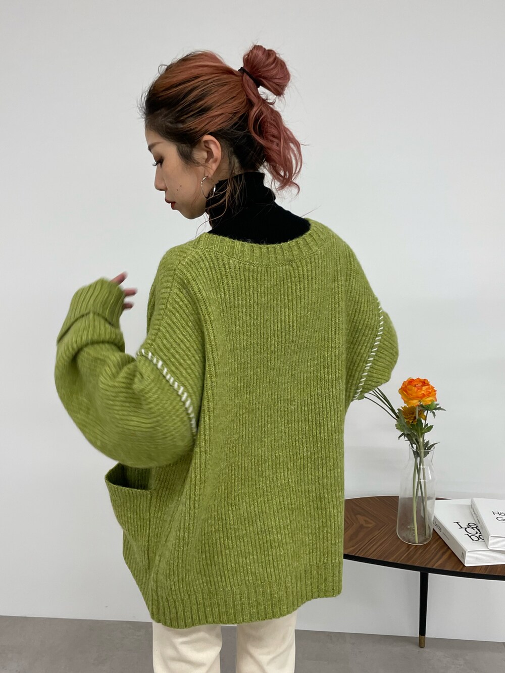 ホワイト系のデニムパンツ、グリーン系のカーディガン/ボレロ、ブラック系のニット/セーターを着用したレディースの秋コーディネートの5枚目の写真