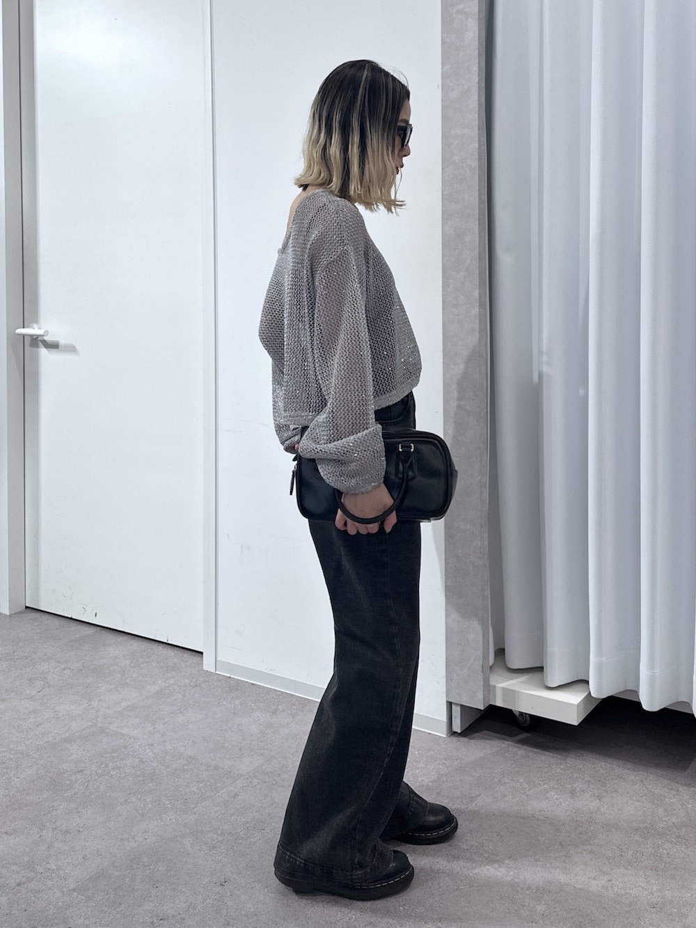 ブラック系のデニムパンツ、グレー系のニット/セーター、ブラック系のキャミソールを着用したレディースの春コーディネートの2枚目の写真