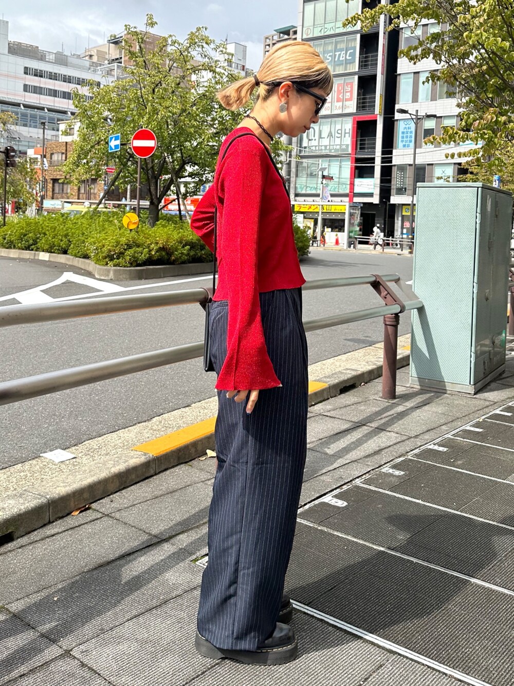 ブルー系のスラックス、レッド系のニット/セーター、ブラック系のベルトを着用したレディースの秋コーディネートの2枚目の写真