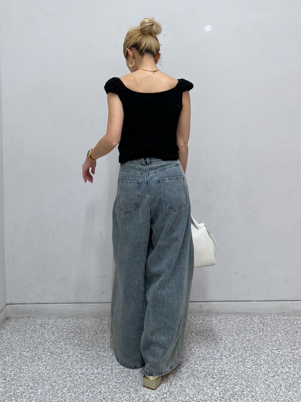 ブラック系のTシャツ/カットソー、ブルー系のデニムパンツ、ゴールド系のパンプスを着用したレディースの春コーディネートの3枚目の写真