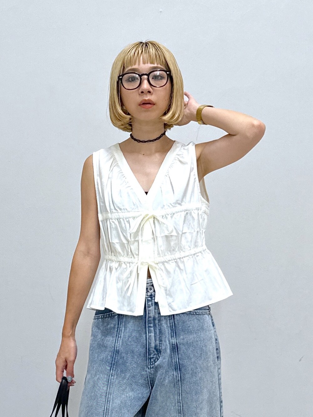 ホワイト系のシャツ/ブラウス、ブルー系のデニムパンツ、ブラック系のハンドバッグを着用したレディースの夏コーディネートの4枚目の写真