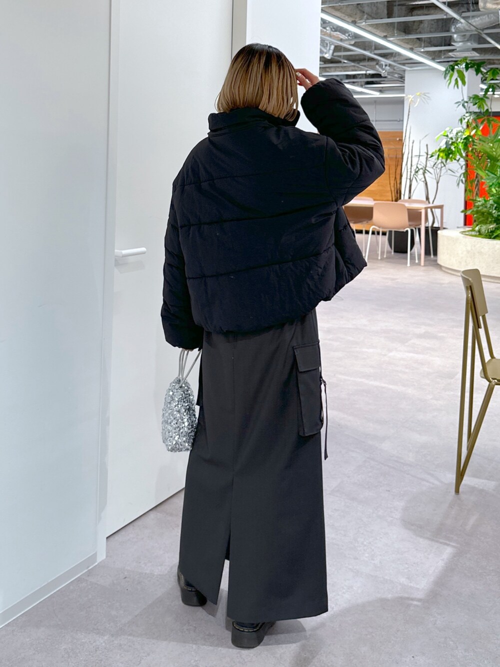 ブラック系のブルゾン、パープル系のニット/セーター、グレー系のスカートを着用したレディースの冬コーディネートの3枚目の写真