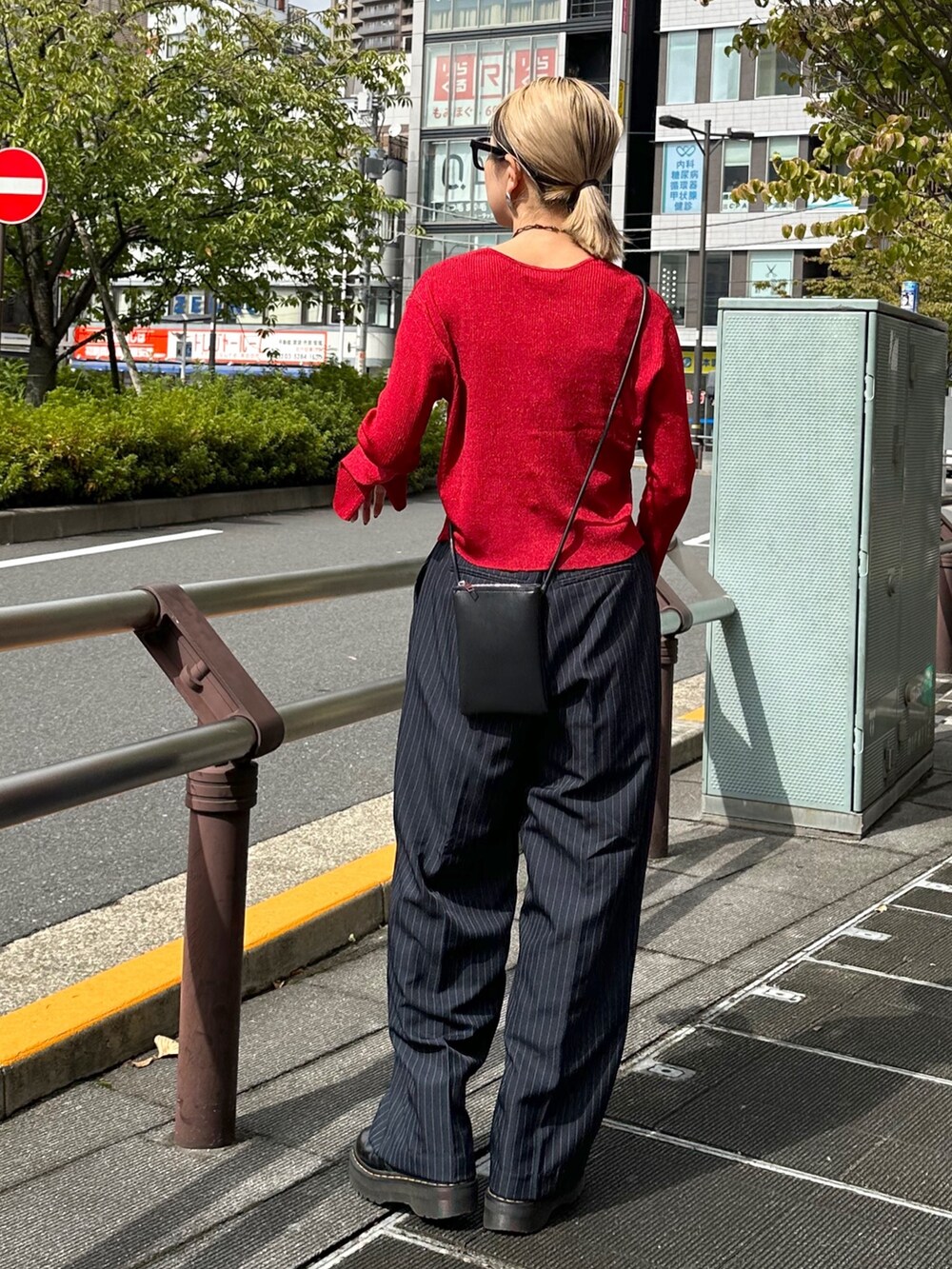 ブルー系のスラックス、レッド系のニット/セーター、ブラック系のベルトを着用したレディースの秋コーディネートの3枚目の写真