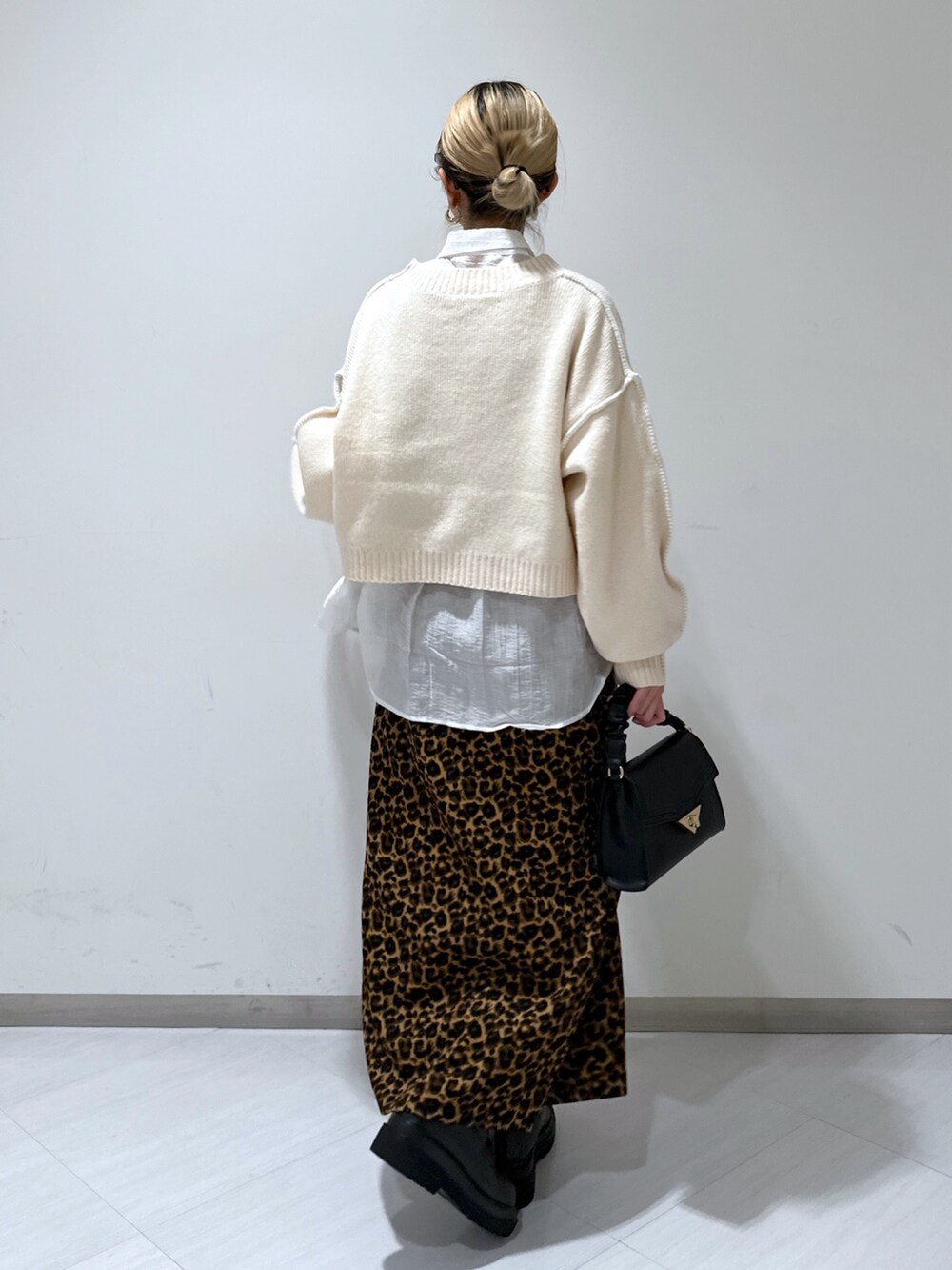 ホワイト系のニット/セーター、ホワイト系のシャツ/ブラウス、ブラウン系のスカートを着用したレディースの冬コーディネートの3枚目の写真