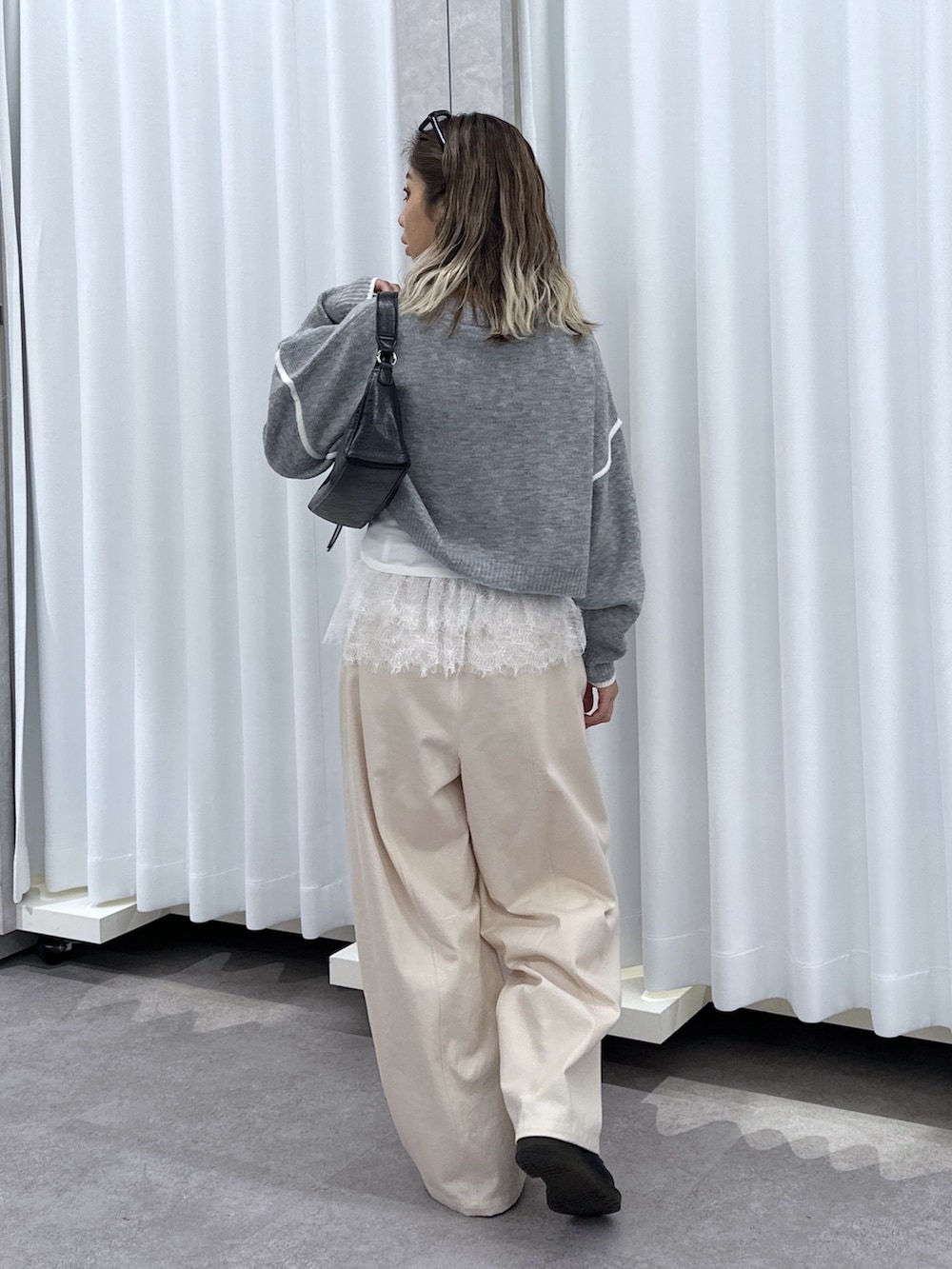 グレー系のニット/セーター、ホワイト系のTシャツ/カットソー、ホワイト系のその他パンツを着用したレディースの夏コーディネートの3枚目の写真