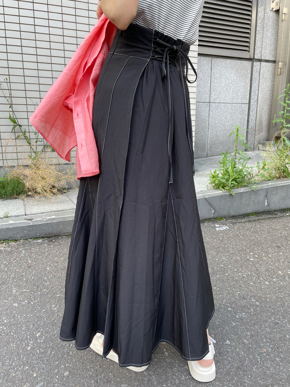 ピンク系のシャツ/ブラウス、ブラック系のスカート、ホワイト系のサンダルを着用したレディースの夏コーディネートの2枚目の写真