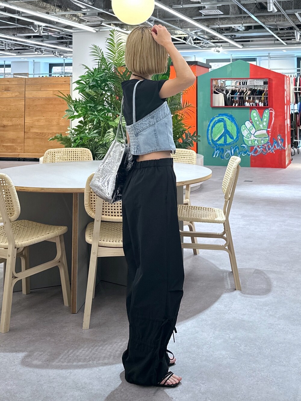 ブルー系のベスト、ブラック系のTシャツ/カットソー、ブラック系のカーゴパンツを着用したレディースの春コーディネートの2枚目の写真
