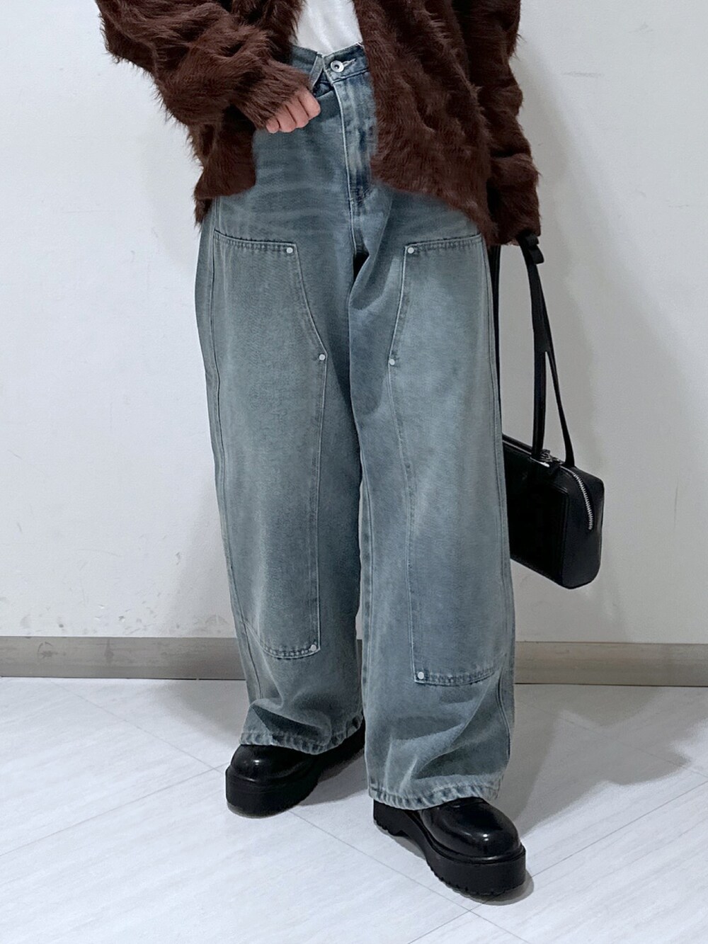 ブラウン系のカーディガン/ボレロ、ホワイト系のTシャツ/カットソー、ブルー系のデニムパンツを着用したレディースの冬コーディネートの5枚目の写真