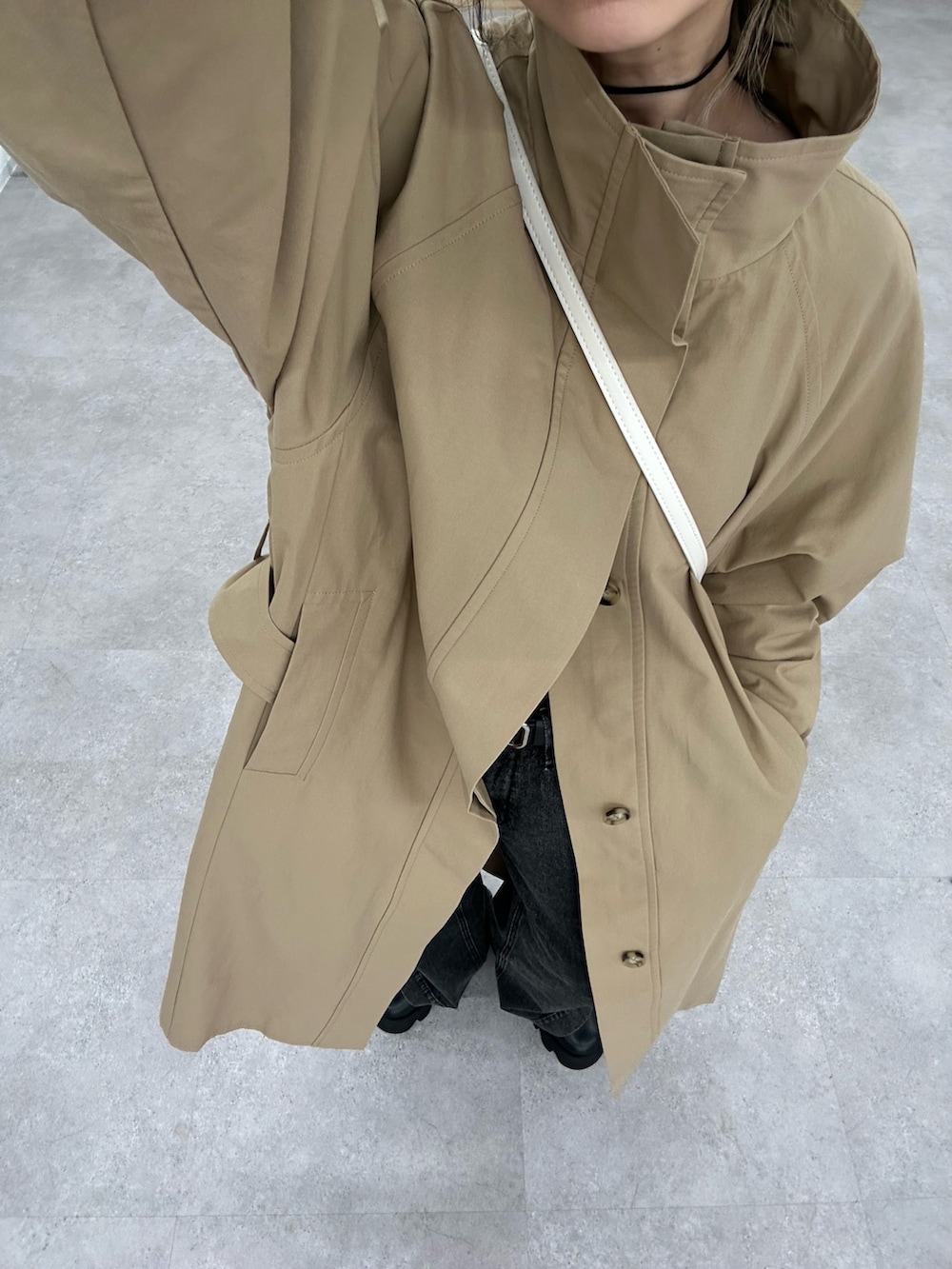 ブラック系のデニムパンツ、ブラック系のシャツ/ブラウス、ベージュ系のトレンチコートを着用したレディースの春コーディネートの6枚目の写真