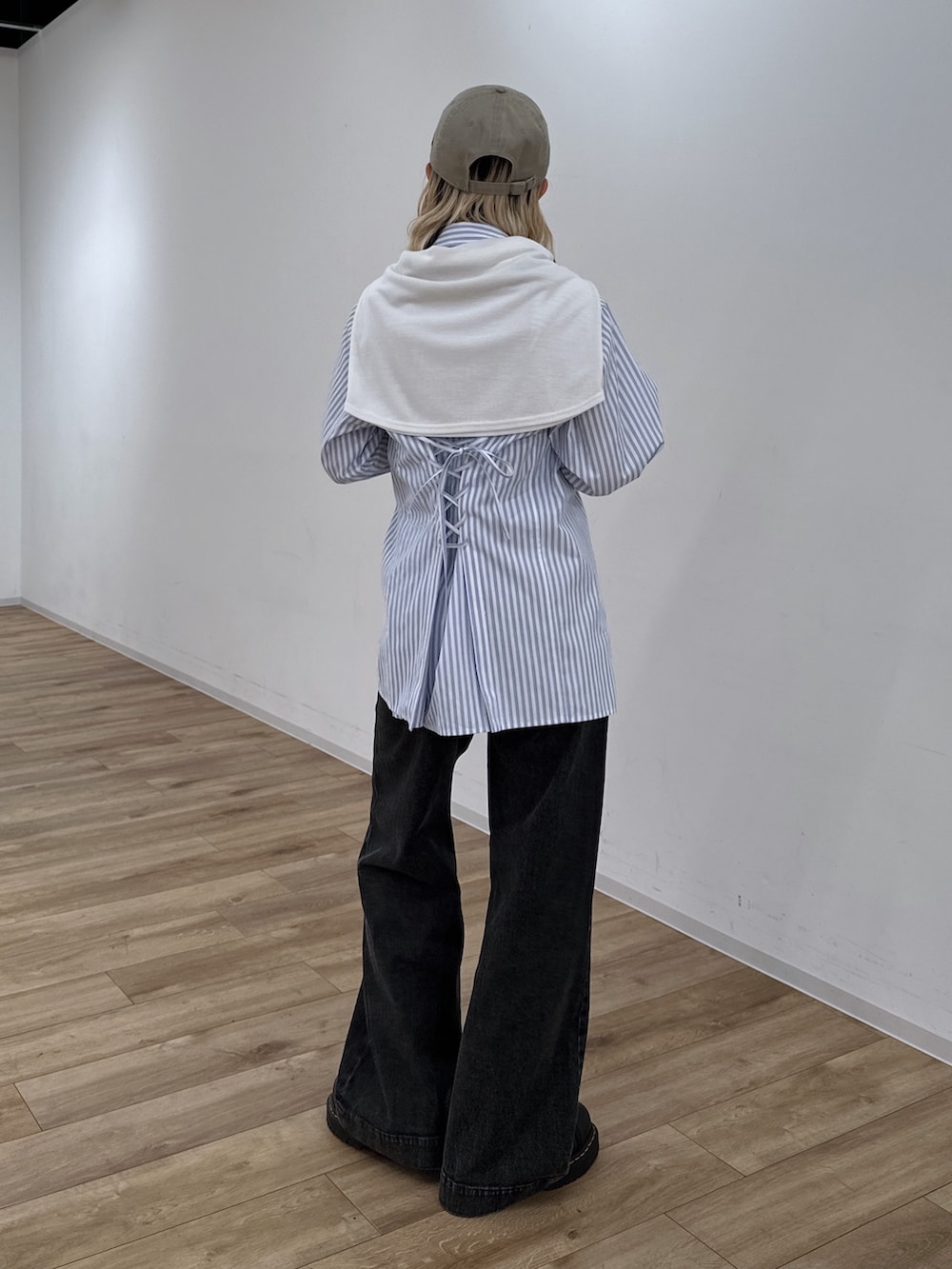 ブルー系のシャツ/ブラウス、ブラック系のデニムパンツ、ホワイト系のハンドバッグを着用したレディースの冬コーディネートの3枚目の写真