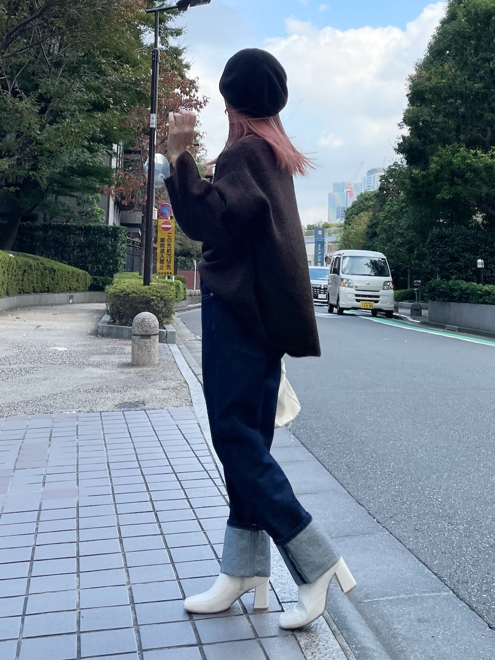 ブルー系のデニムパンツ、ブラウン系のニット/セーター、ホワイト系のブーツを着用したレディースの秋コーディネートの2枚目の写真