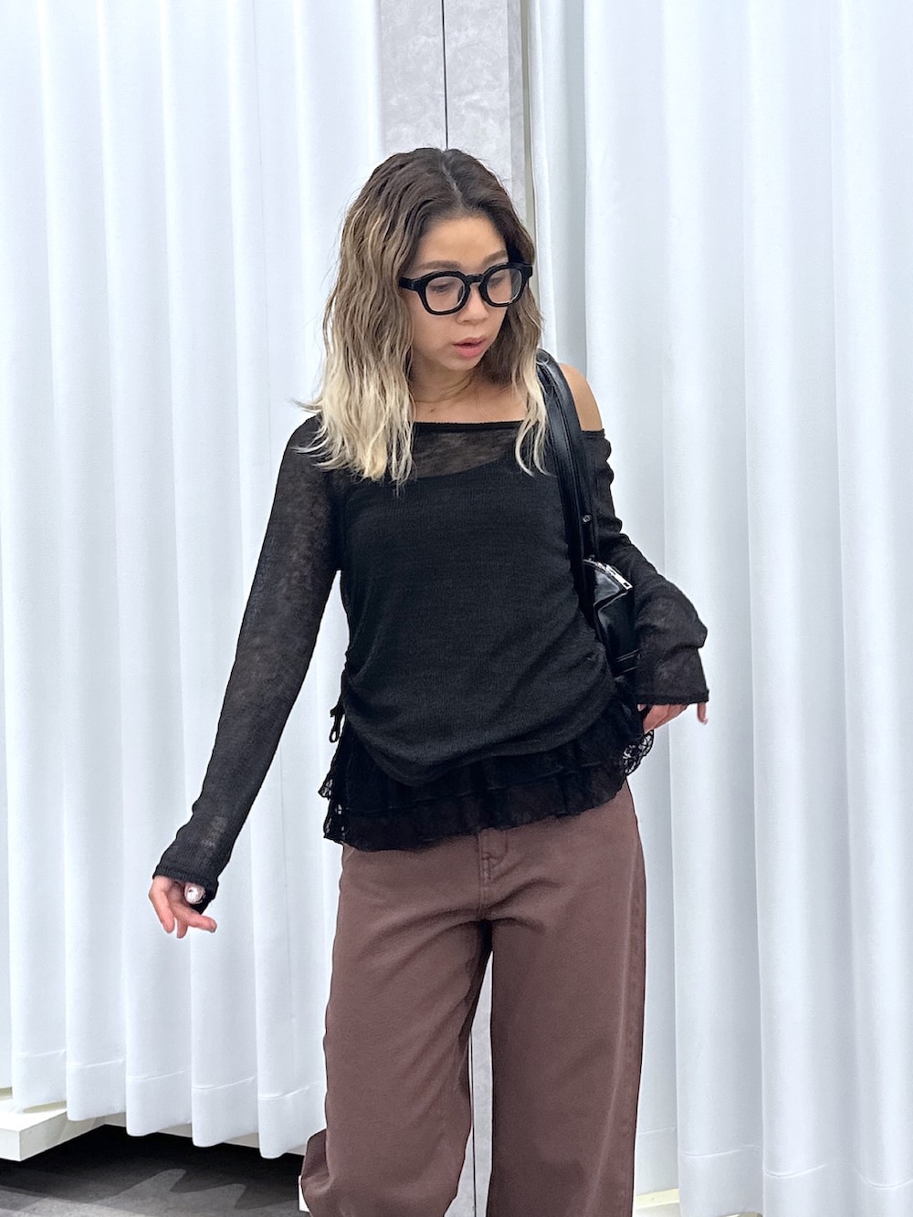 ブラック系のTシャツ/カットソー、ブラウン系のデニムパンツ、ブラック系のショルダーバッグを着用したレディースの秋コーディネートの4枚目の写真