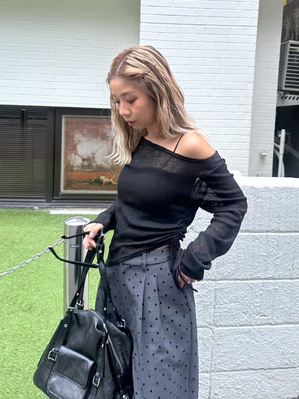 ブラック系のTシャツ/カットソー、ブラック系のキャミソール、グレー系のスラックスを着用したレディースの秋コーディネートの4枚目の写真