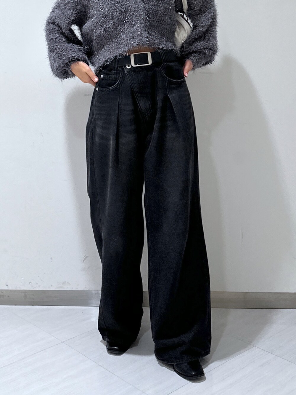 グレー系のカーディガン/ボレロ、ブラック系のデニムパンツ、ホワイト系のトートバッグを着用したレディースの秋コーディネートの5枚目の写真