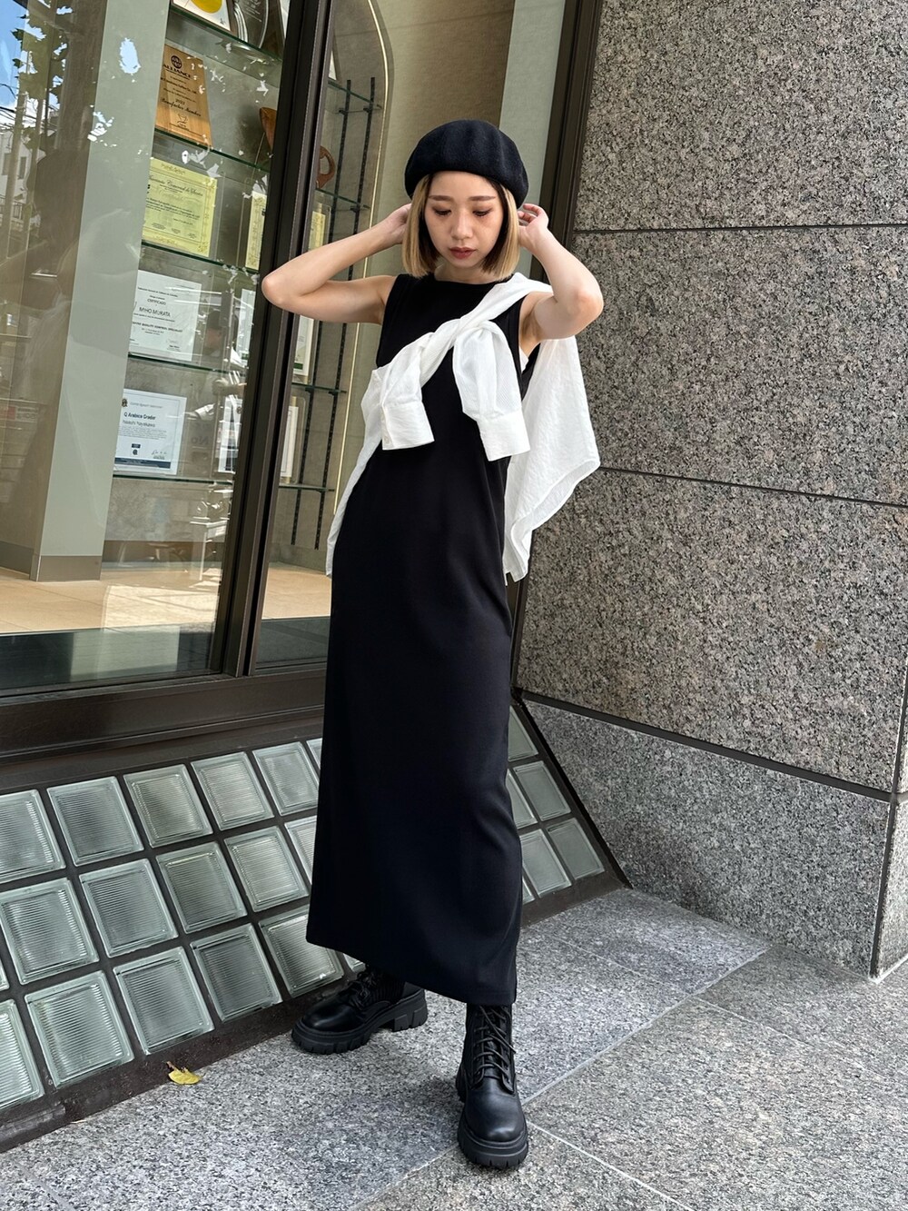 ブラック系のワンピース、ホワイト系のシャツ/ブラウス、ブラック系のブーツを着用したレディースの夏コーディネートの2枚目の写真