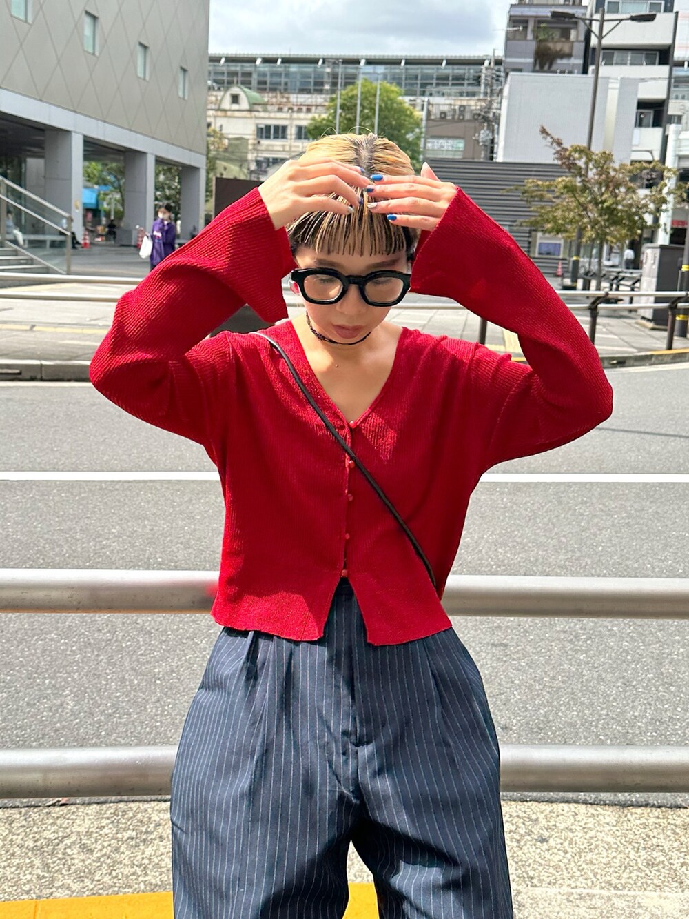 ブルー系のスラックス、レッド系のニット/セーター、ブラック系のベルトを着用したレディースの秋コーディネートの4枚目の写真