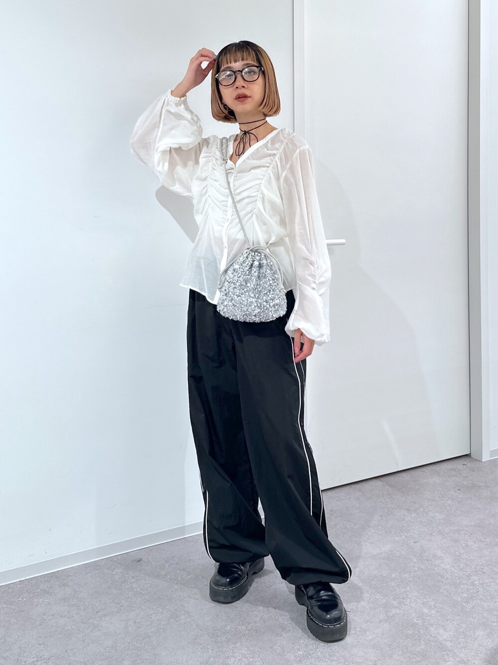 ブラック系のその他パンツ、シルバー系のハンドバッグ、ホワイト系のシャツ/ブラウスを着用したレディースの春コーディネートの2枚目の写真