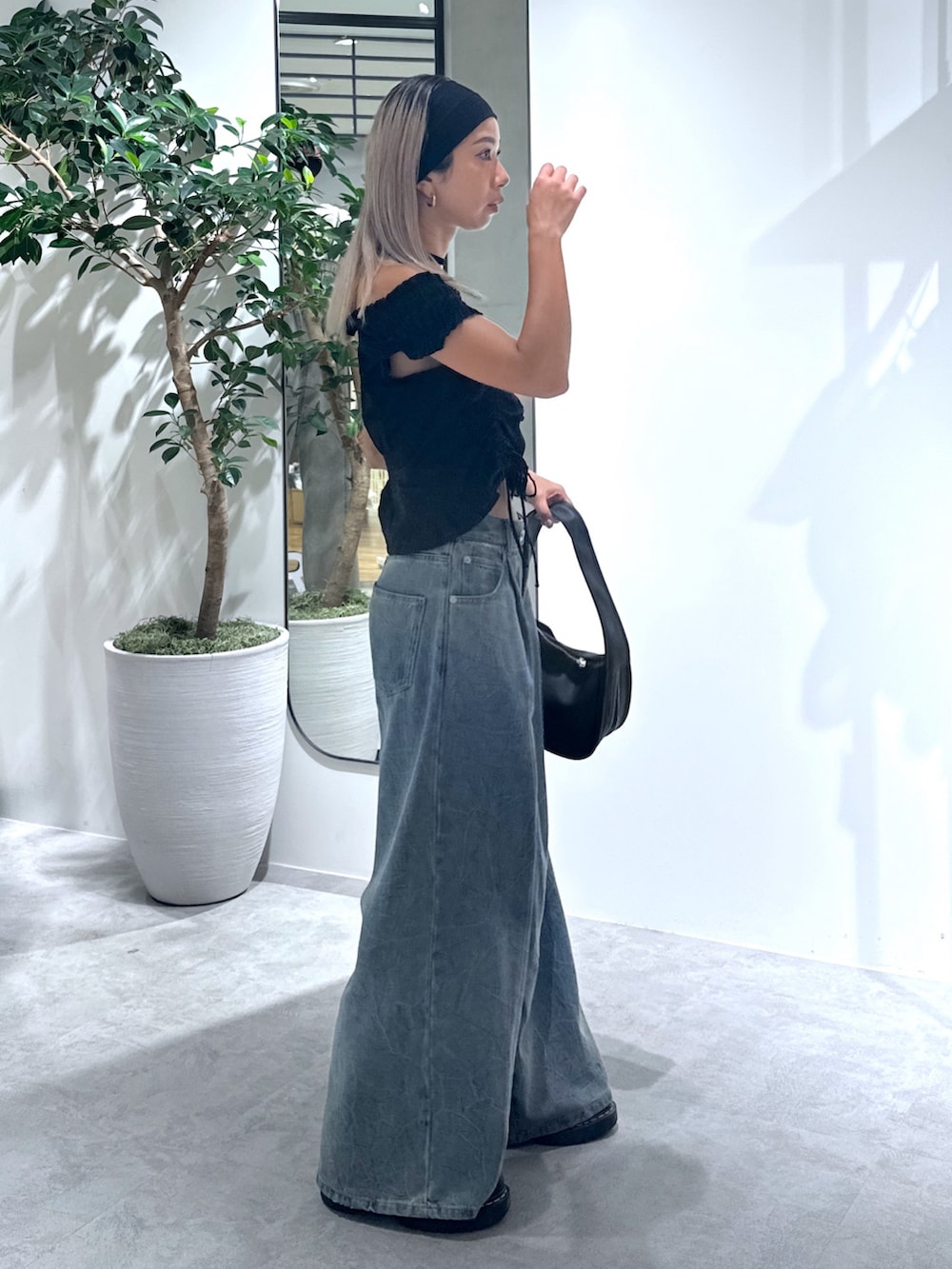 ブラック系のシャツ/ブラウス、ブルー系のその他パンツ、ブラック系のハンドバッグを着用したレディースの夏コーディネートの2枚目の写真