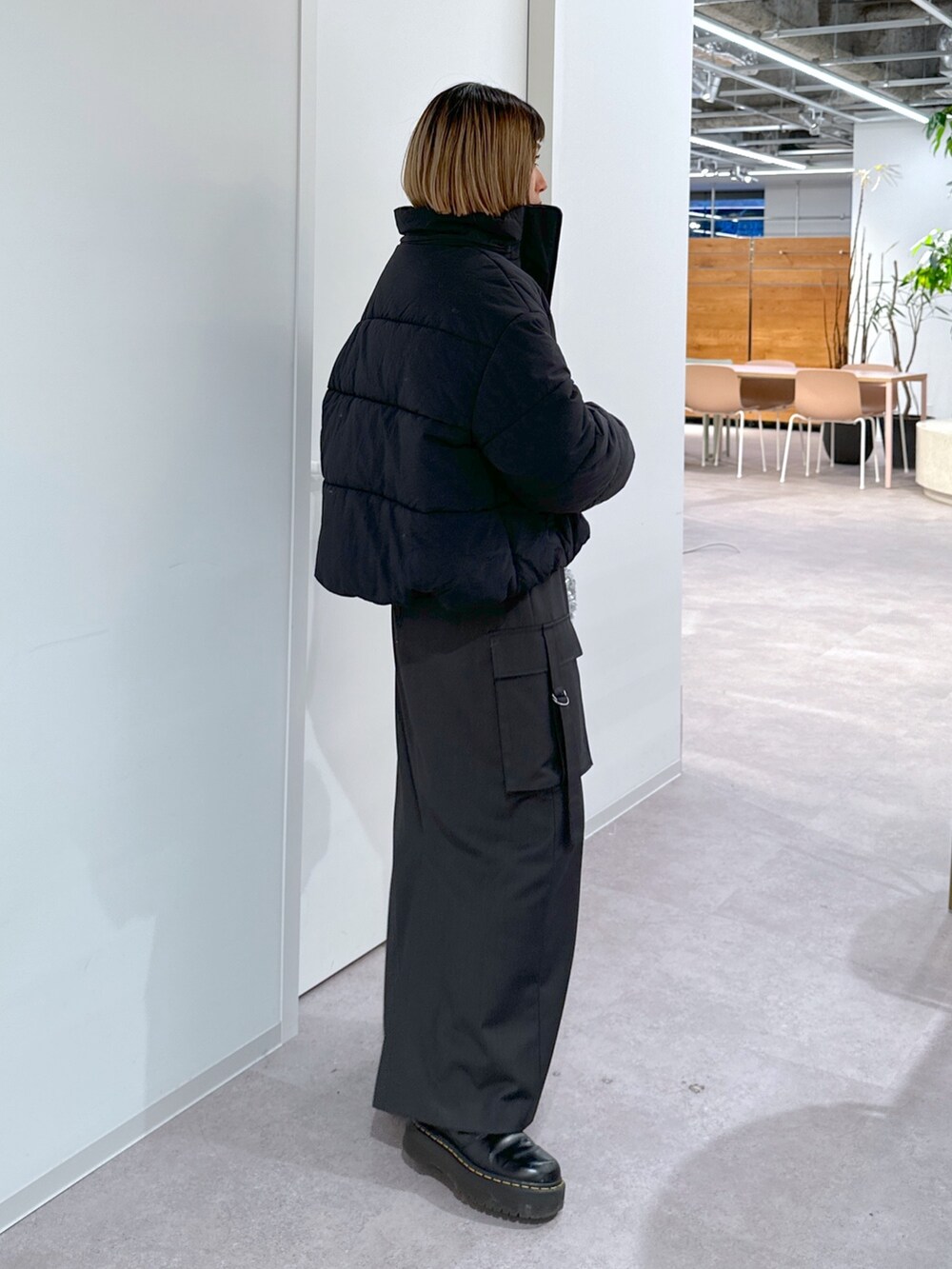 ブラック系のブルゾン、パープル系のニット/セーター、グレー系のスカートを着用したレディースの冬コーディネートの2枚目の写真