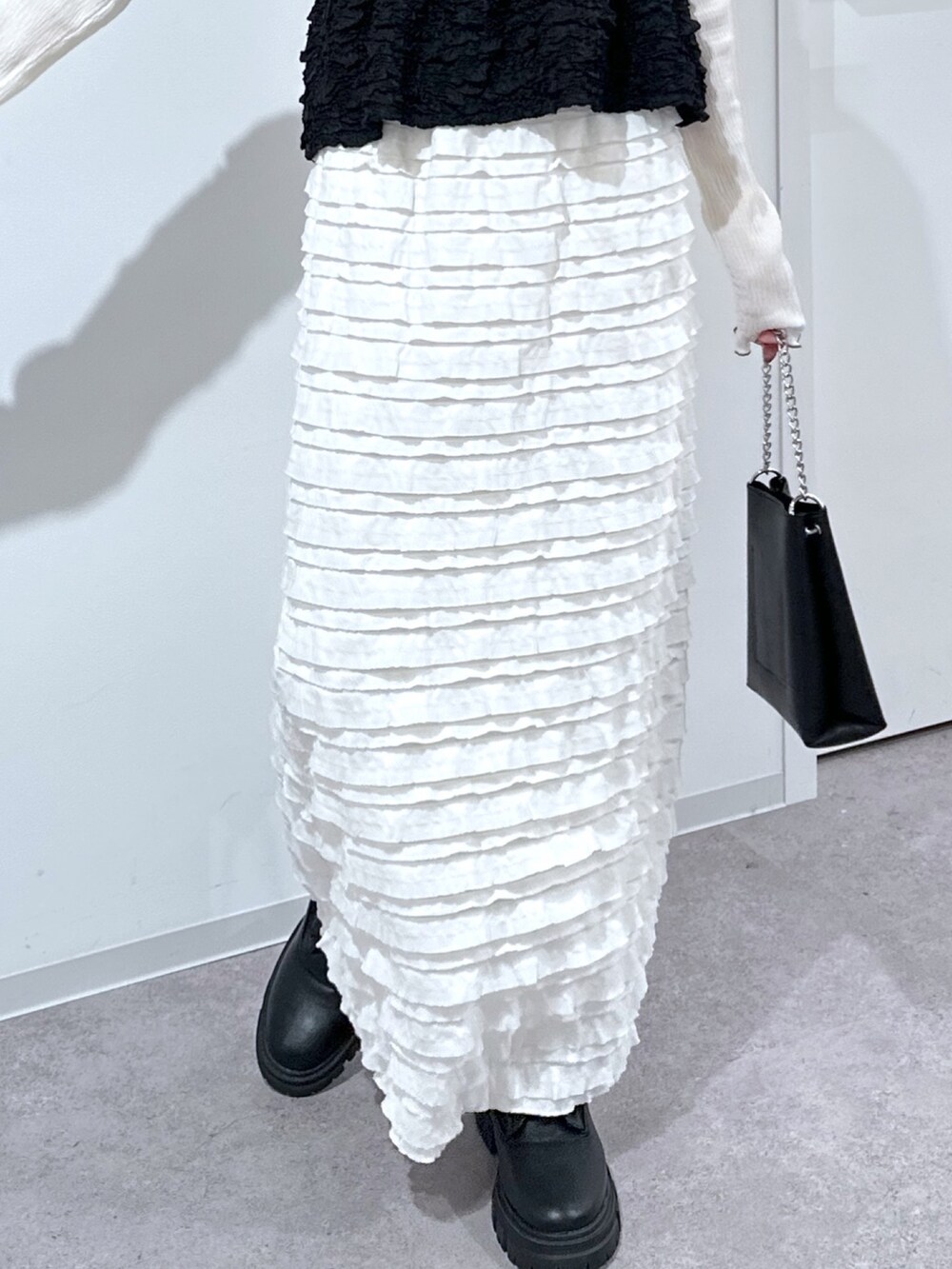 ホワイト系のTシャツ/カットソー、ブラック系のシャツ/ブラウス、ホワイト系のスカートを着用したレディースの春コーディネートの5枚目の写真