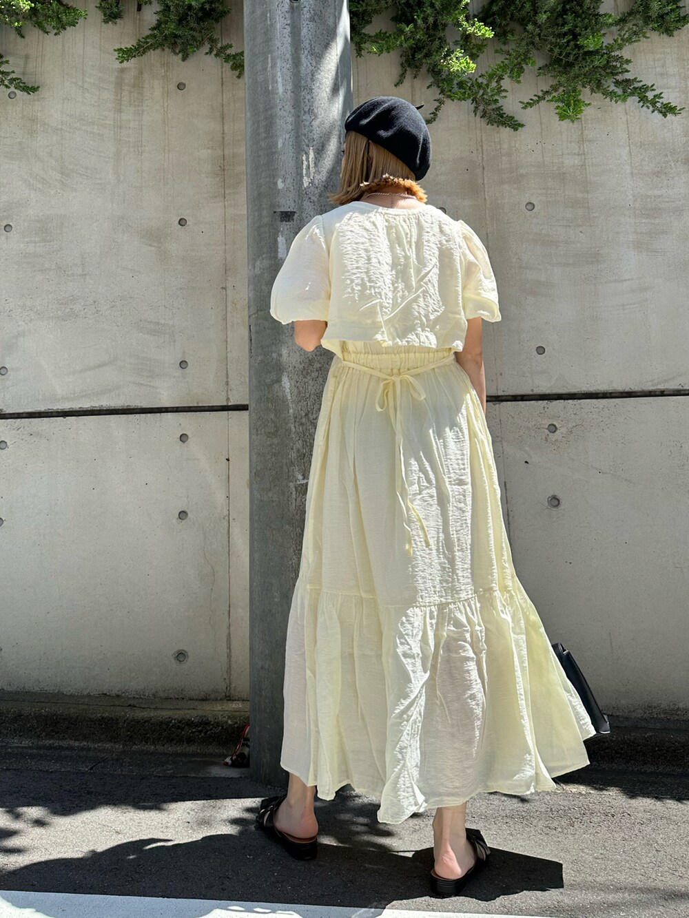 ホワイト系のワンピース、ブラック系のショルダーバッグ、ブラック系のサンダルを着用したレディースの春コーディネートの4枚目の写真