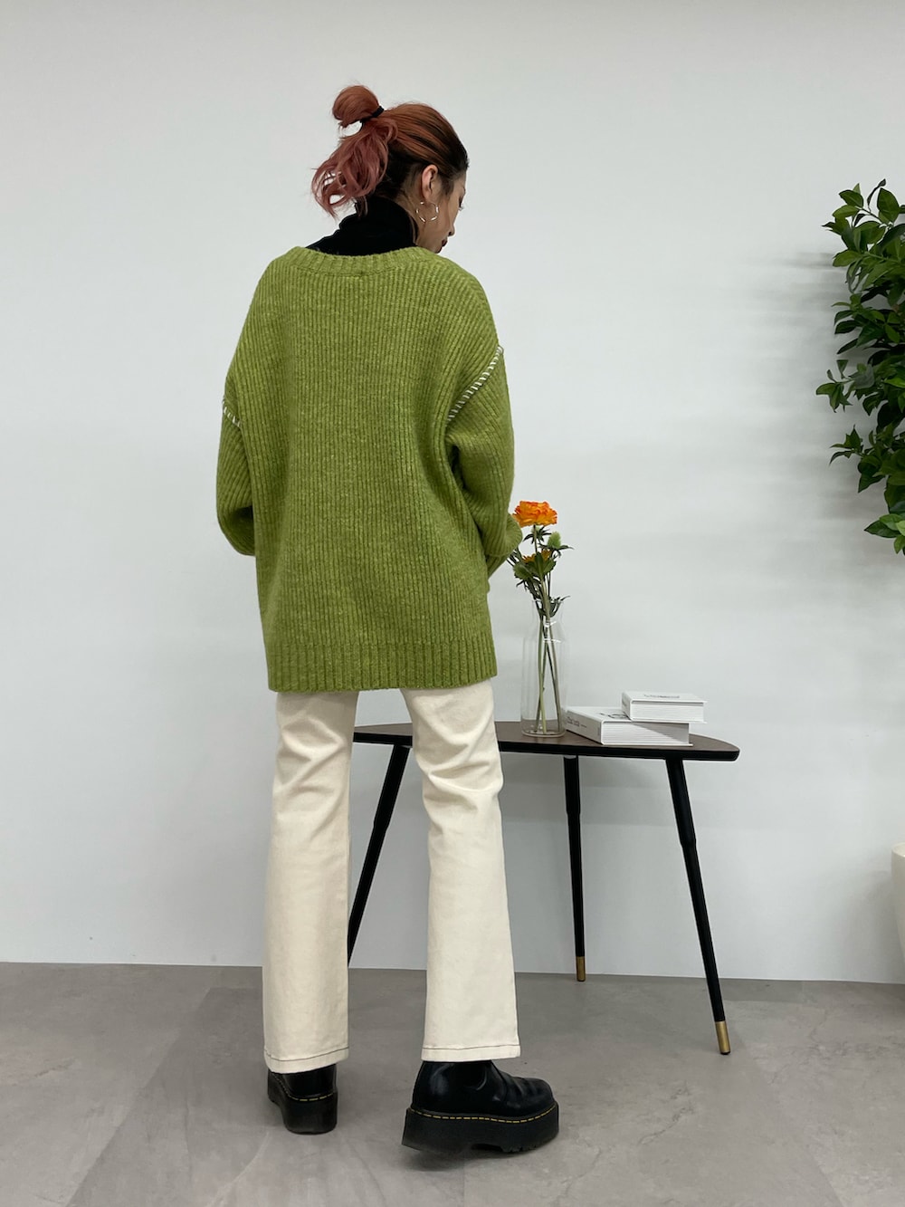 ホワイト系のデニムパンツ、グリーン系のカーディガン/ボレロ、ブラック系のニット/セーターを着用したレディースの秋コーディネートの3枚目の写真