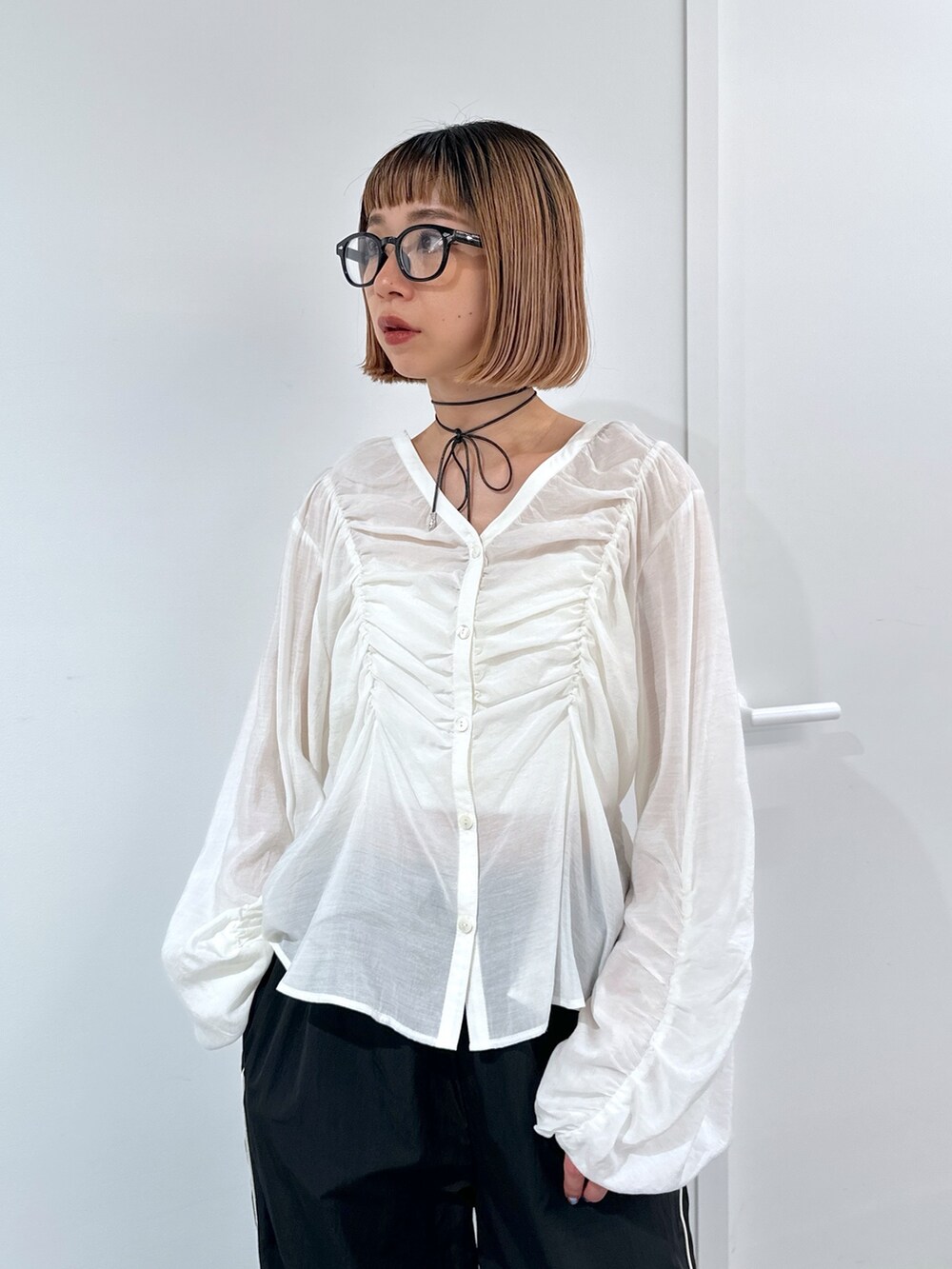 ブラック系のその他パンツ、シルバー系のハンドバッグ、ホワイト系のシャツ/ブラウスを着用したレディースの春コーディネートの5枚目の写真