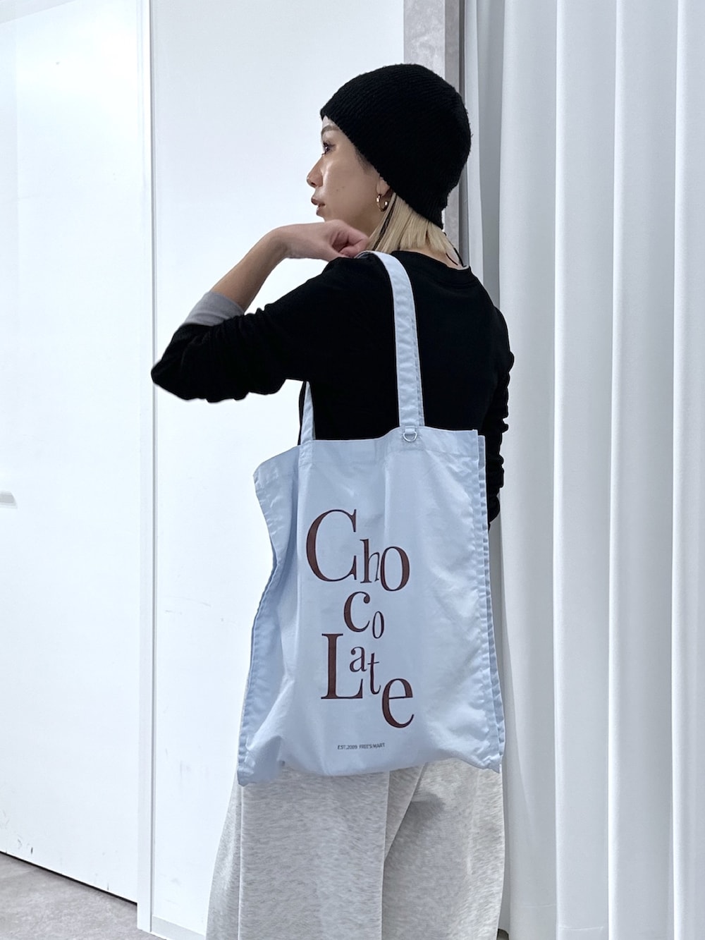 ブラック系のTシャツ/カットソー、ホワイト系のその他パンツ、ブルー系のトートバッグを着用したレディースの春コーディネートの9枚目の写真