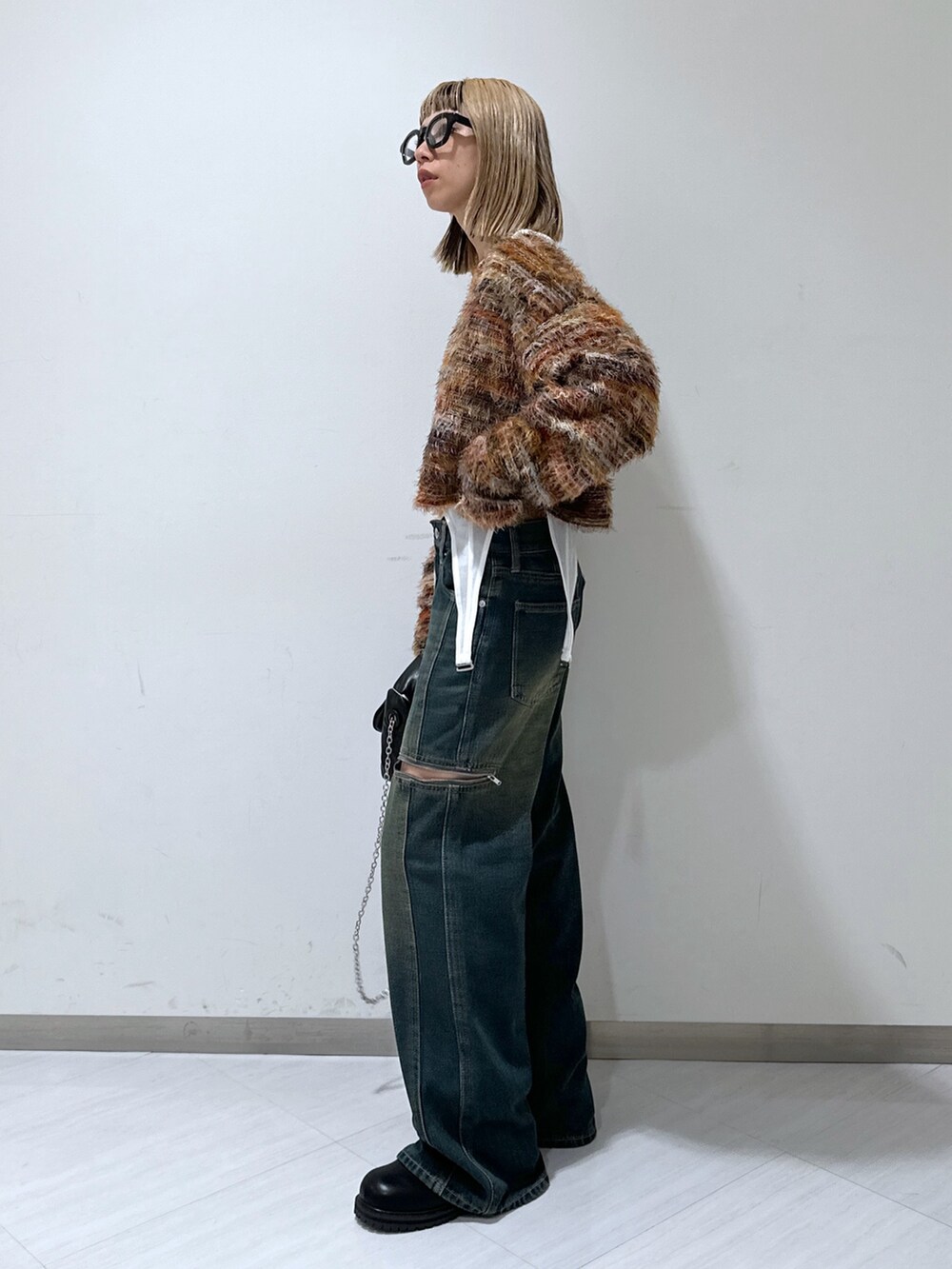 ブルー系のデニムパンツ、レッド系のニット/セーター、ブラック系のショルダーバッグを着用したレディースの秋コーディネートの2枚目の写真