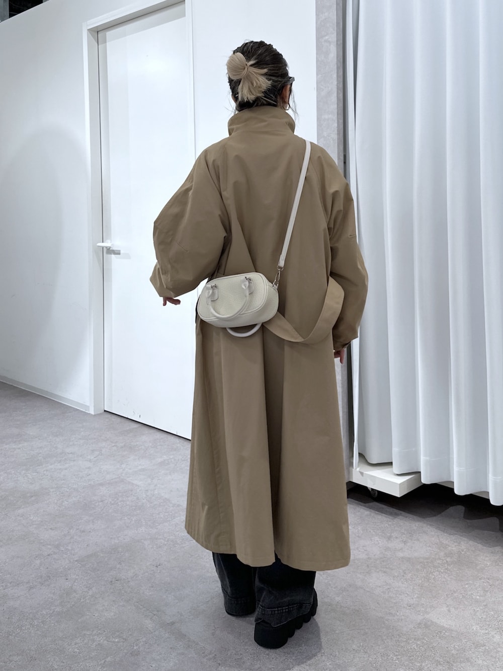 ブラック系のデニムパンツ、ブラック系のシャツ/ブラウス、ベージュ系のトレンチコートを着用したレディースの春コーディネートの3枚目の写真